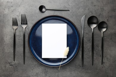 Photo of Empty menu, plate, cutlery and dry spike on grey table, flat lay. Mockup for design