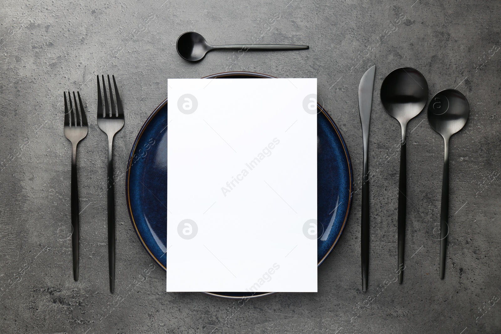 Photo of Empty menu, plate, cutlery and dry spike on grey table, flat lay. Mockup for design