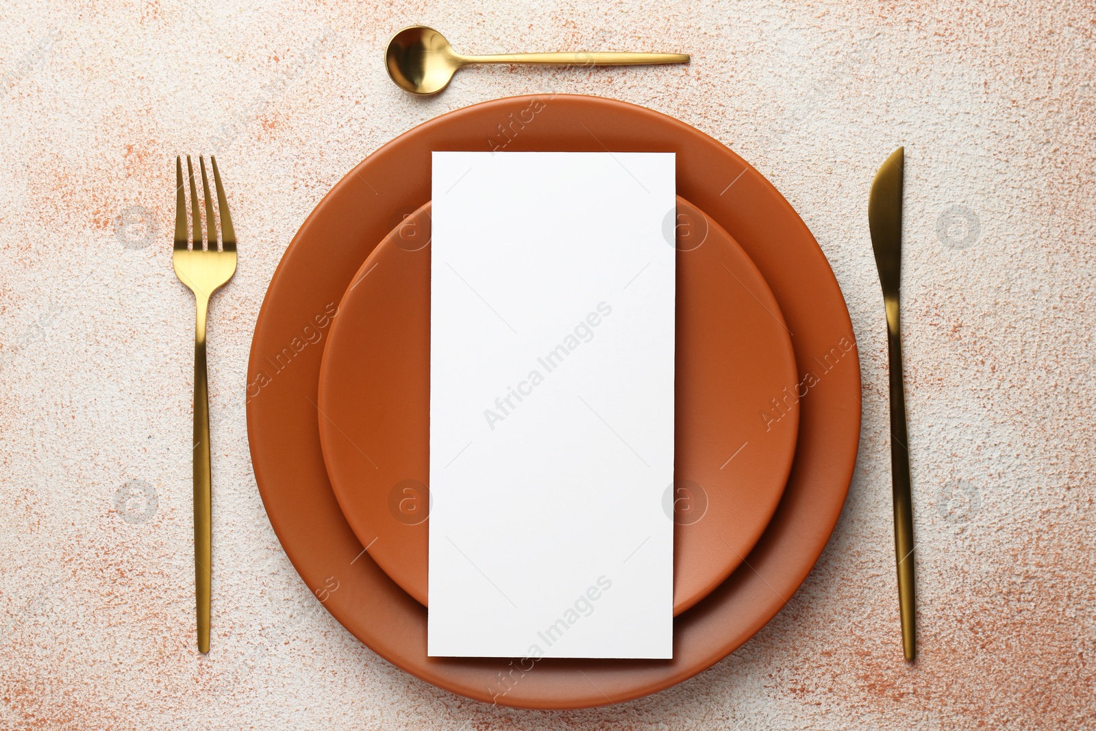 Photo of Empty menu, cutlery and plates on color textured table, top view. Mockup for design