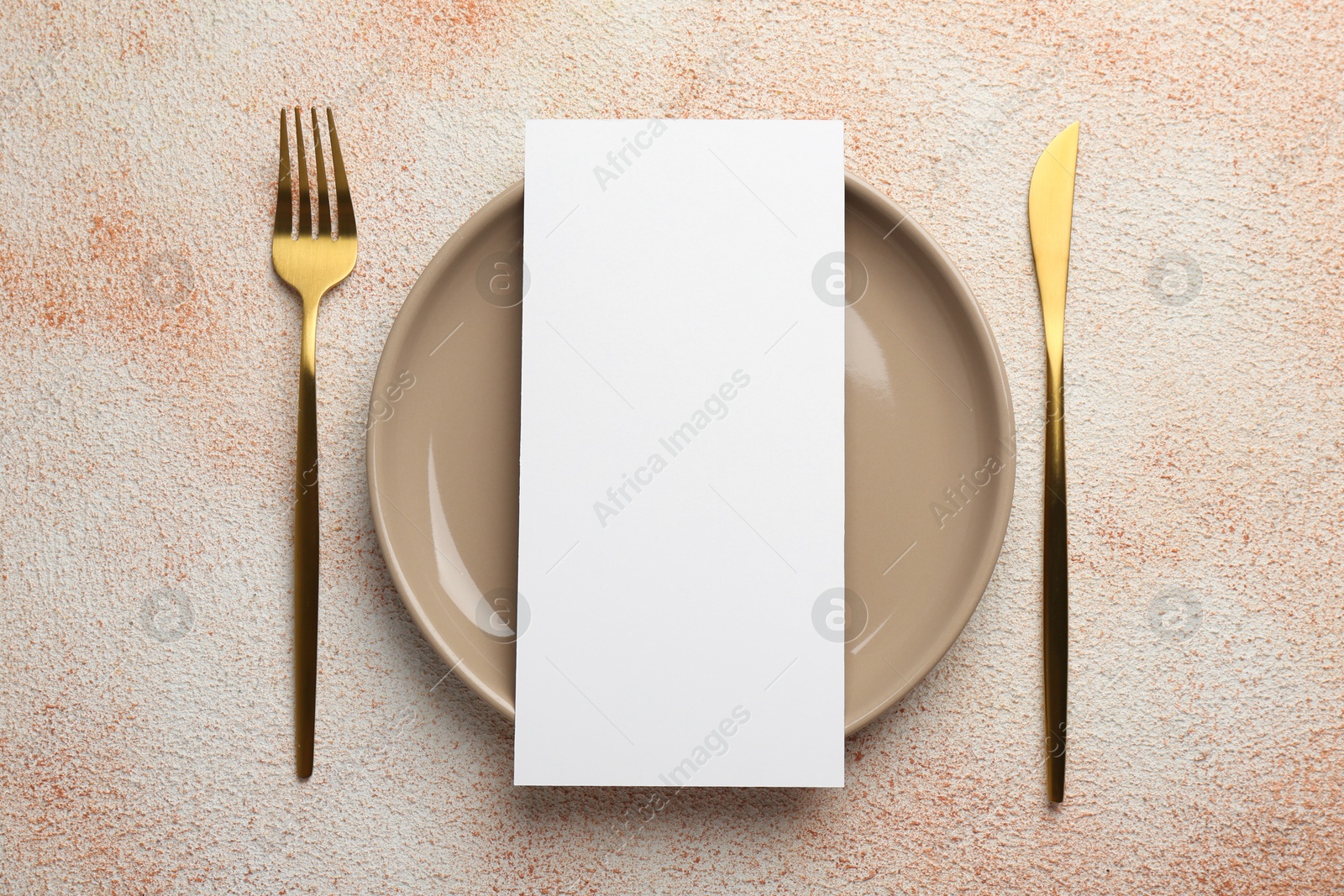 Photo of Empty menu, cutlery and plate on color textured table, top view. Mockup for design