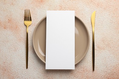 Photo of Empty menu, cutlery and plate on color textured table, top view. Mockup for design