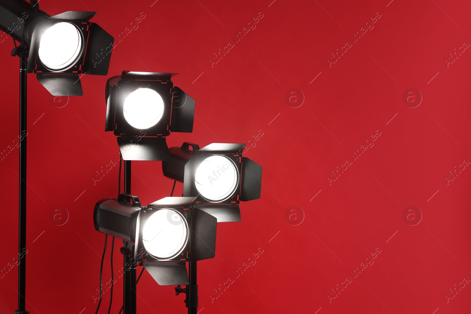 Photo of Red photo background and professional lighting equipment in studio, space for text