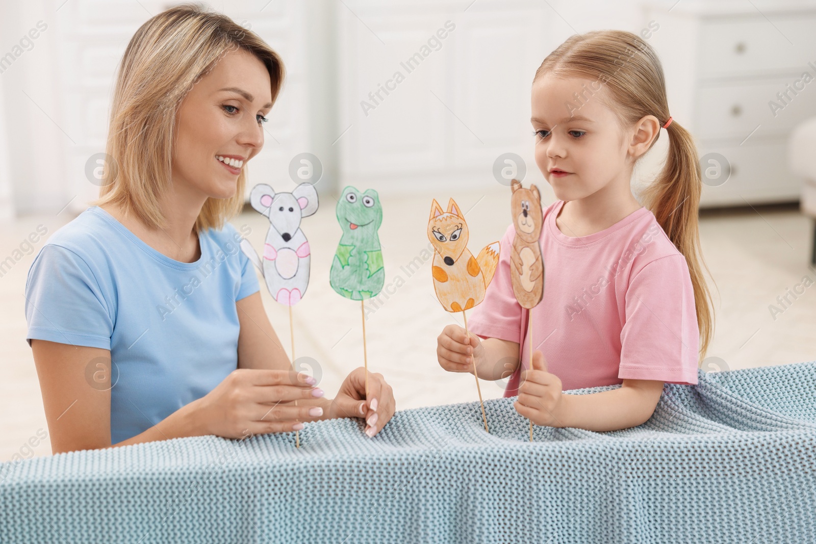 Photo of Puppet theatre. Mother and daughter performing show at home