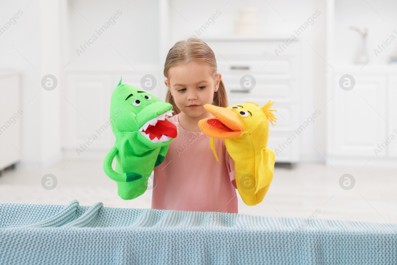 Photo of Puppet theatre. Cute girl performing show with toys at home