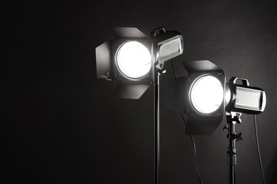 Dark photo background and professional lighting equipment in studio