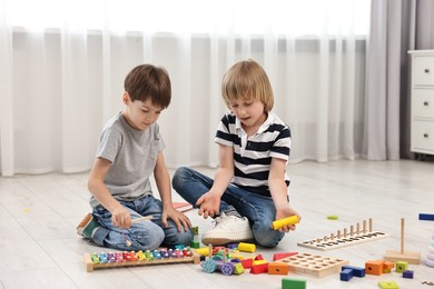 Photo of Cute little children playing together on floor indoors