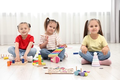 Cute little children playing together on floor indoors