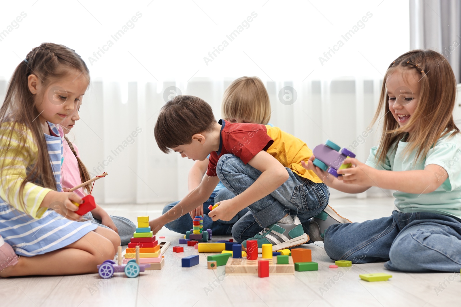 Photo of Group of children playing together on floor indoors