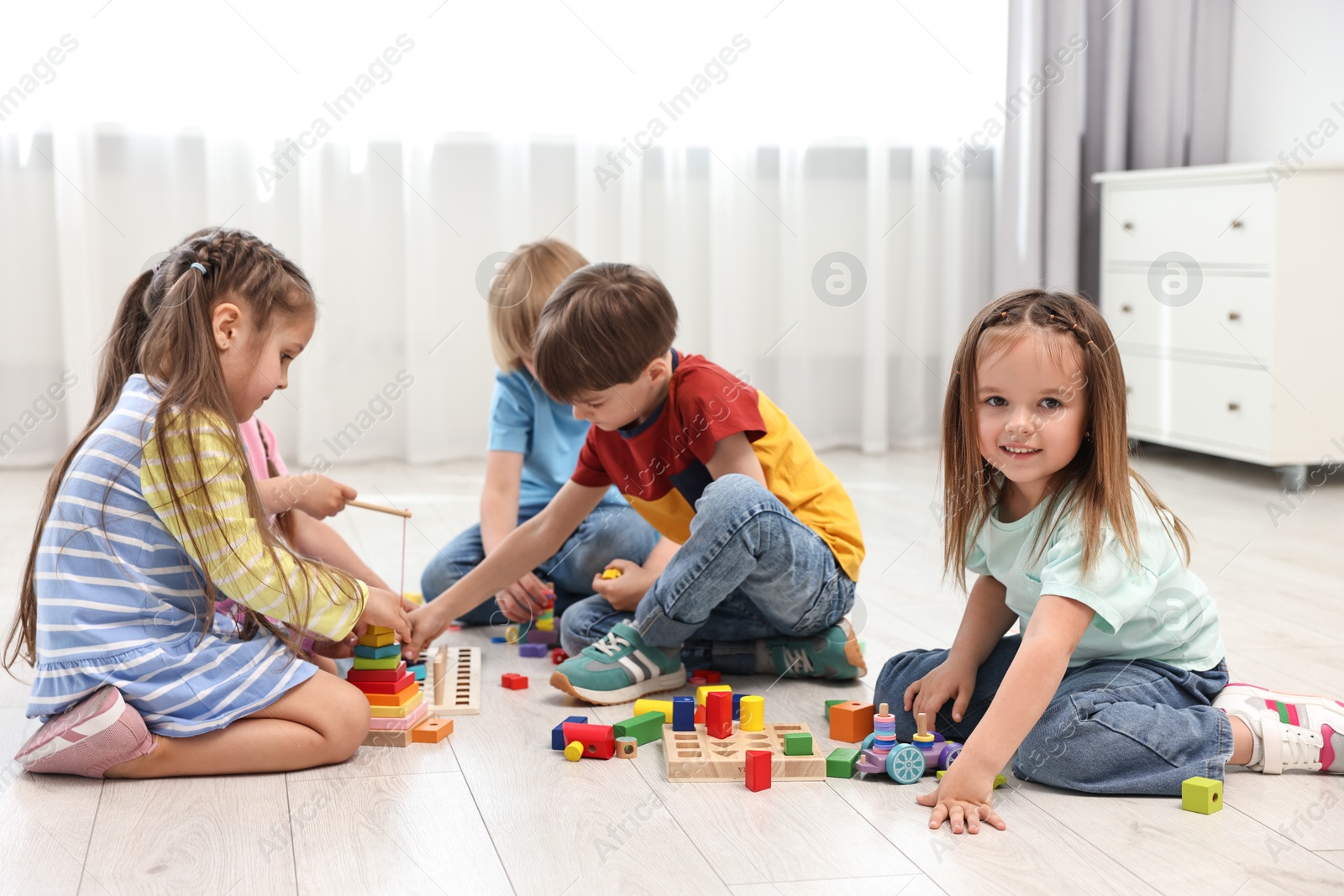 Photo of Group of children playing together on floor indoors