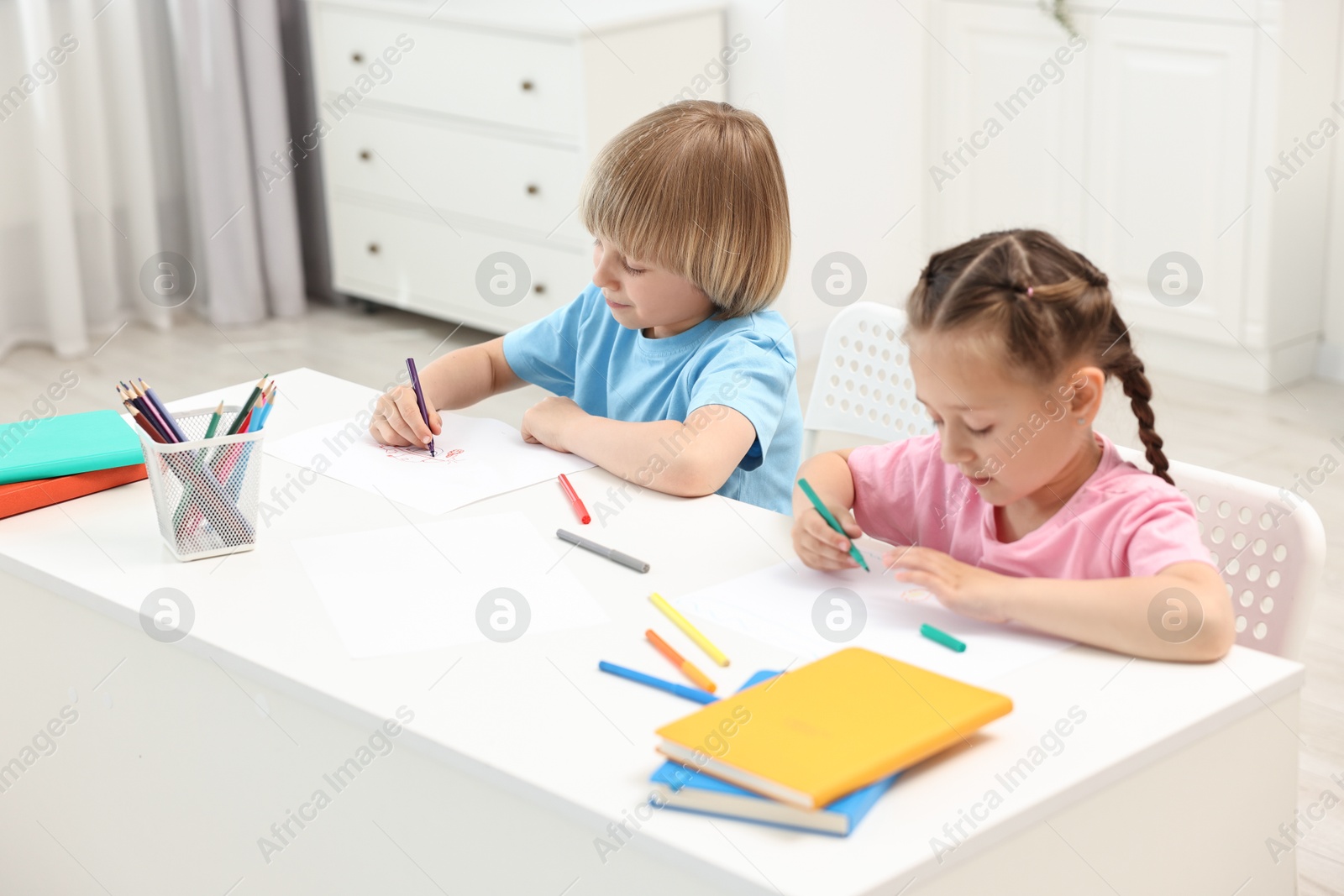 Photo of Cute little children drawing at table indoors