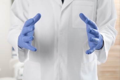 Photo of Doctor in gloves holding something indoors, selective focus