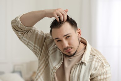 Baldness concept. Sad man with receding hairline indoors