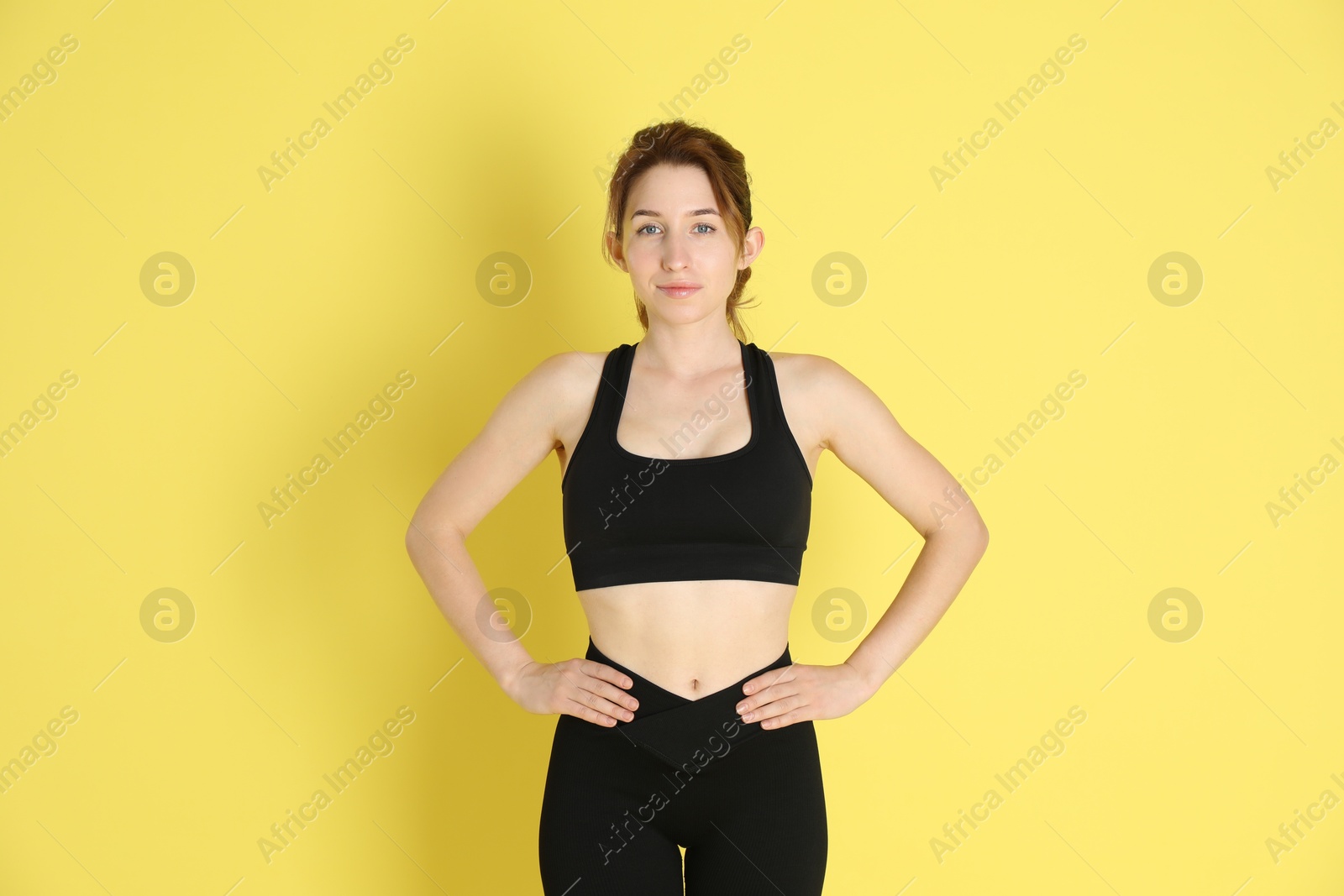 Photo of Woman with slim body posing on yellow background