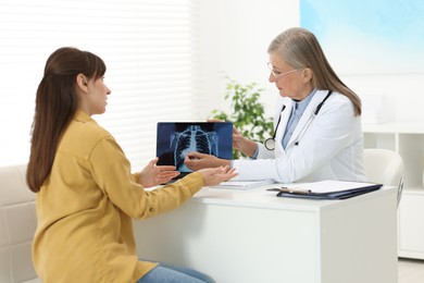 Lung cancer. Doctor showing chest x-ray on laptop to her patient in clinic