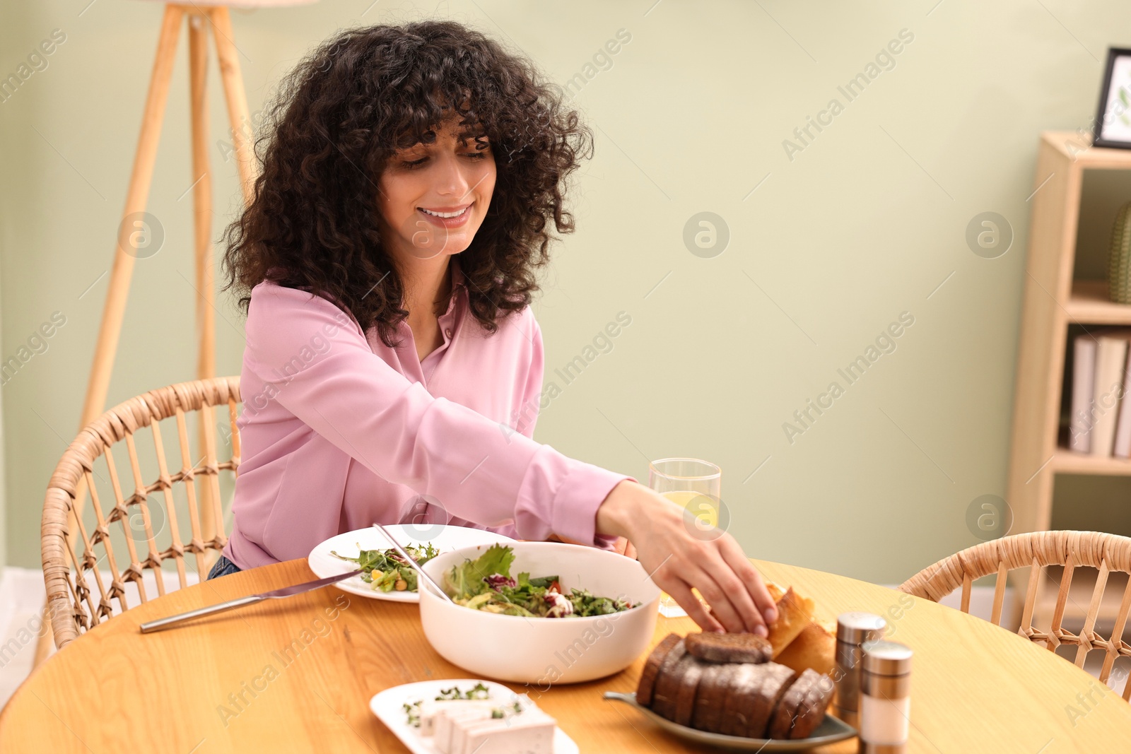 Photo of Woman having vegetarian meal at table in cafe