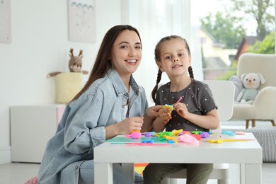 Photo of Play dough activity. Family portrait of smiling mother with her daughter at home