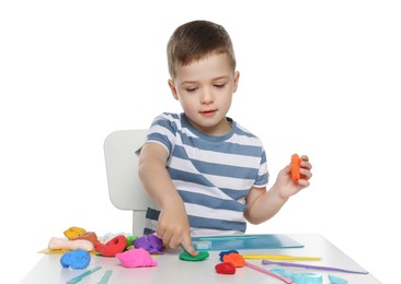 Photo of Little boy sculpting with play dough at table on white background