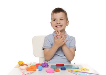Photo of Smiling boy sculpting with play dough at table on white background