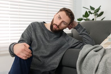 Photo of Loneliness concept. Sad man sitting on sofa at home