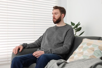 Photo of Loneliness concept. Sad man sitting on sofa at home