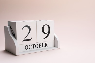 Photo of International Psoriasis Day - 29th of October. Block calendar on beige background, space for text