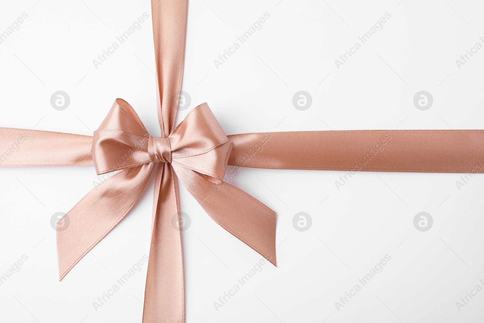 Photo of Beige satin ribbon with bow on white background, top view