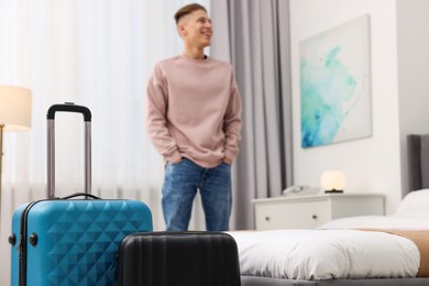 Photo of Guest exploring stylish hotel room, focus on suitcases