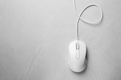 Wired mouse on grey textured table, top view. Space for text