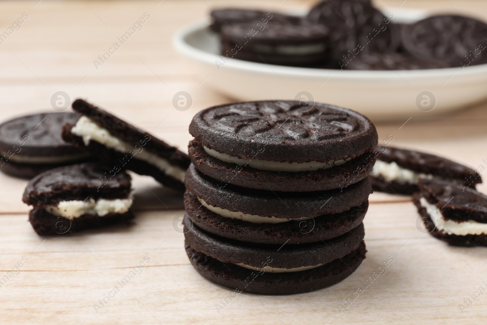 Photo of Tasty sandwich cookies on light wooden table, closeup