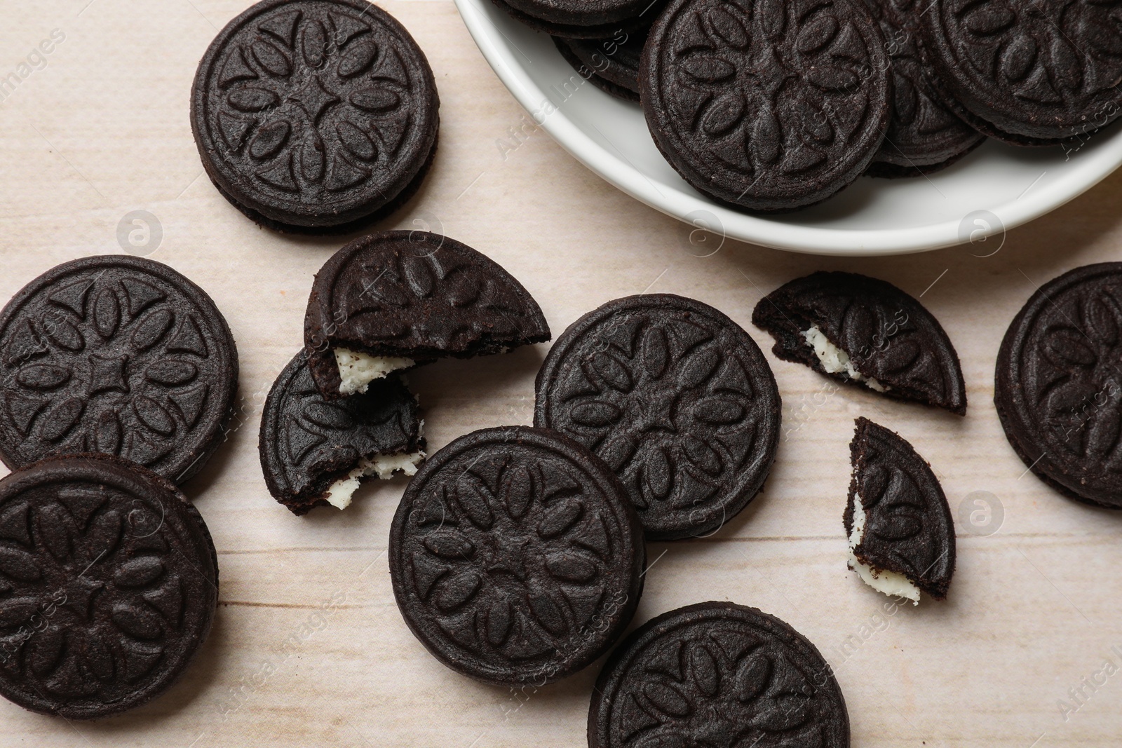 Photo of Tasty sandwich cookies on light wooden table, flat lay