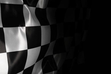 Checkered flag on black background, space for text