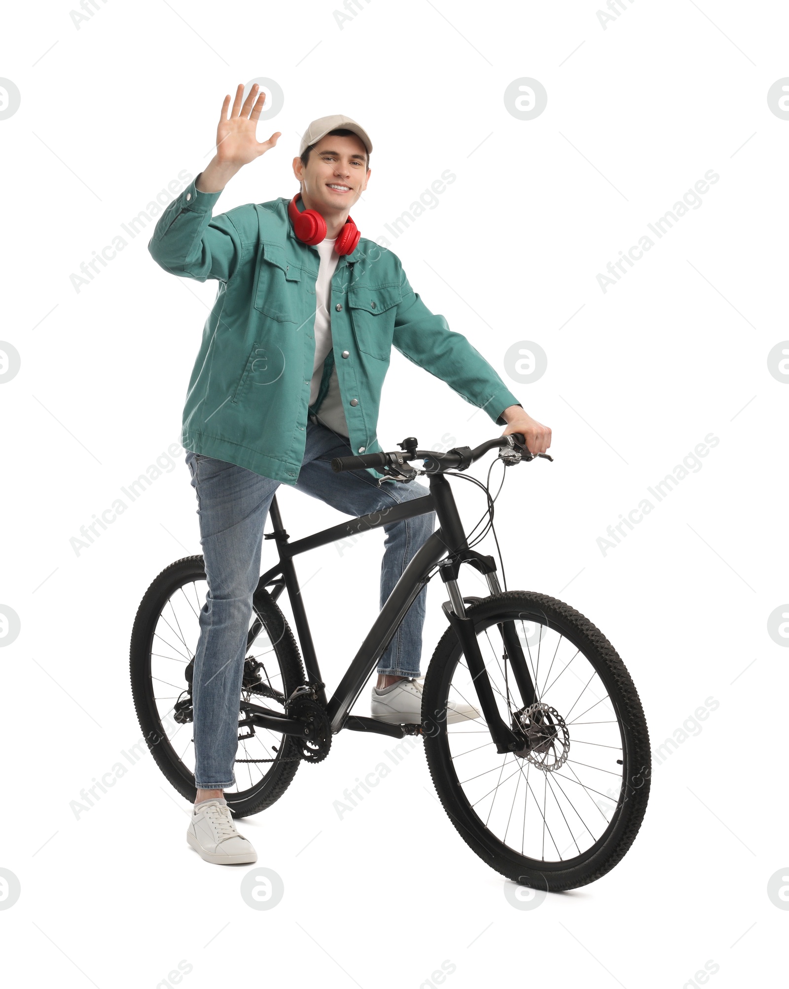 Photo of Smiling man with headphones on bicycle against white background