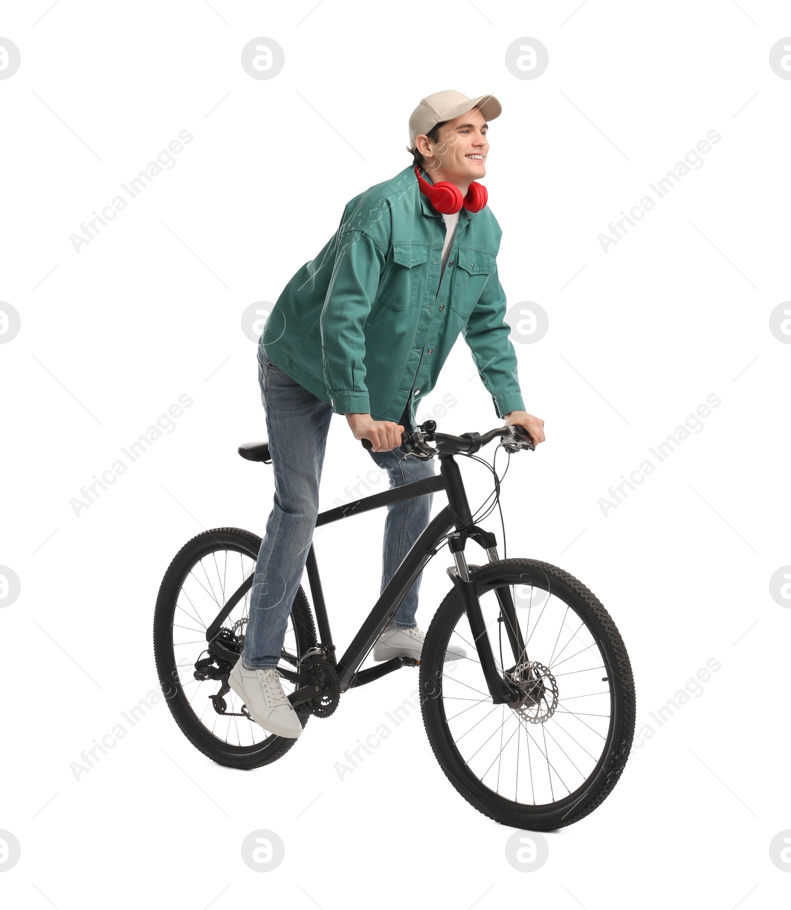 Photo of Smiling man with headphones riding bicycle on white background