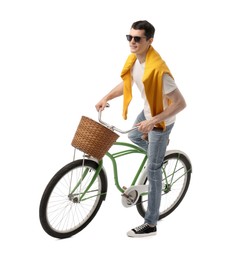 Man in sunglasses riding bicycle with basket on white background