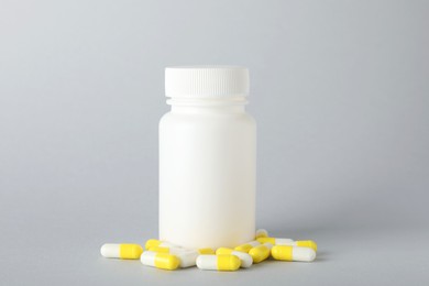 Photo of Antibiotic pills and bottle on grey background. Medicinal treatment