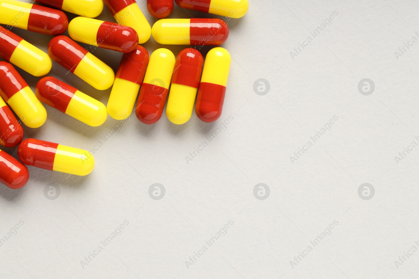 Photo of Many antibiotic pills on grey background, top view and space for text. Medicinal treatment