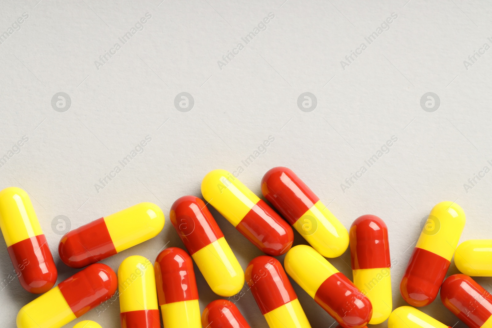 Photo of Many antibiotic pills on grey background, top view and space for text. Medicinal treatment