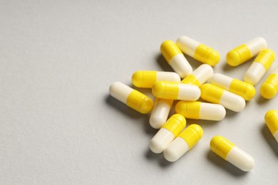 Many antibiotic pills on grey background, closeup and space for text. Medicinal treatment