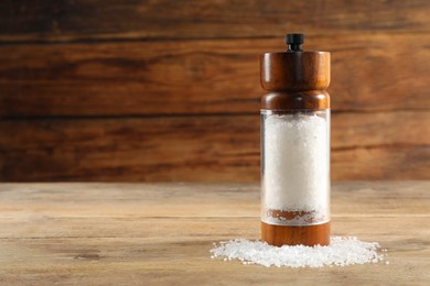 Photo of Salt shaker on wooden table, space for text