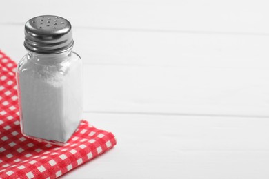 Photo of Salt shaker on white wooden table. Space for text