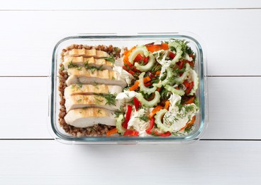 Photo of Healthy meal. Chicken breast, buckwheat and salad in container on white wooden table, top view