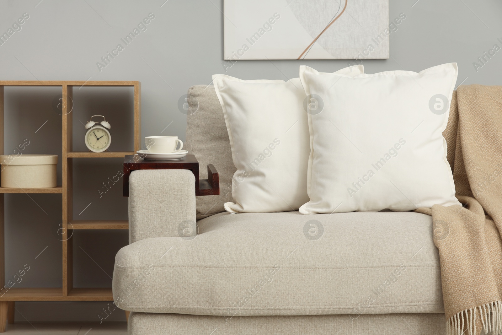 Photo of Soft white pillows and blanket on sofa indoors