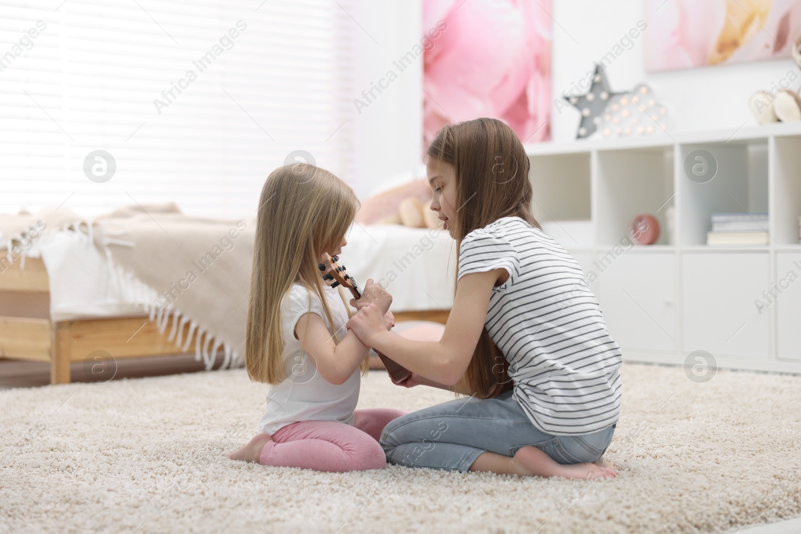 Photo of Cute little sisters spending time together at home