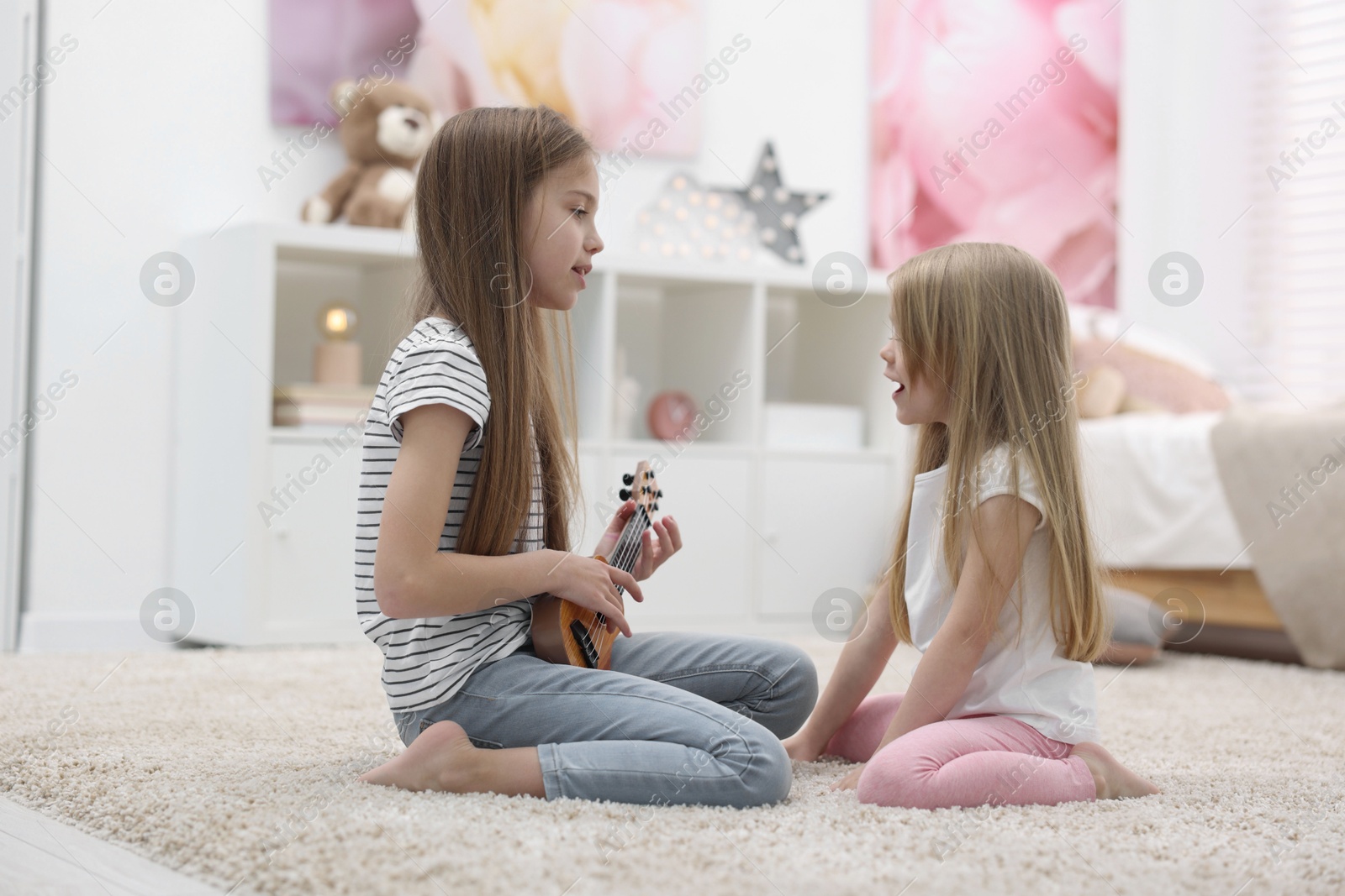 Photo of Cute little sisters spending time together at home