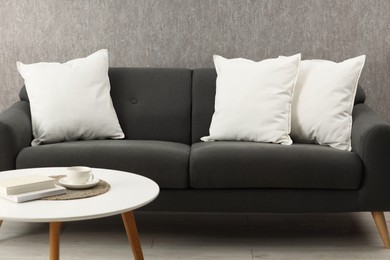 Soft white pillows on sofa and coffee table indoors