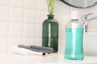 Bottle of mouthwash on white table in bathroom, space for text