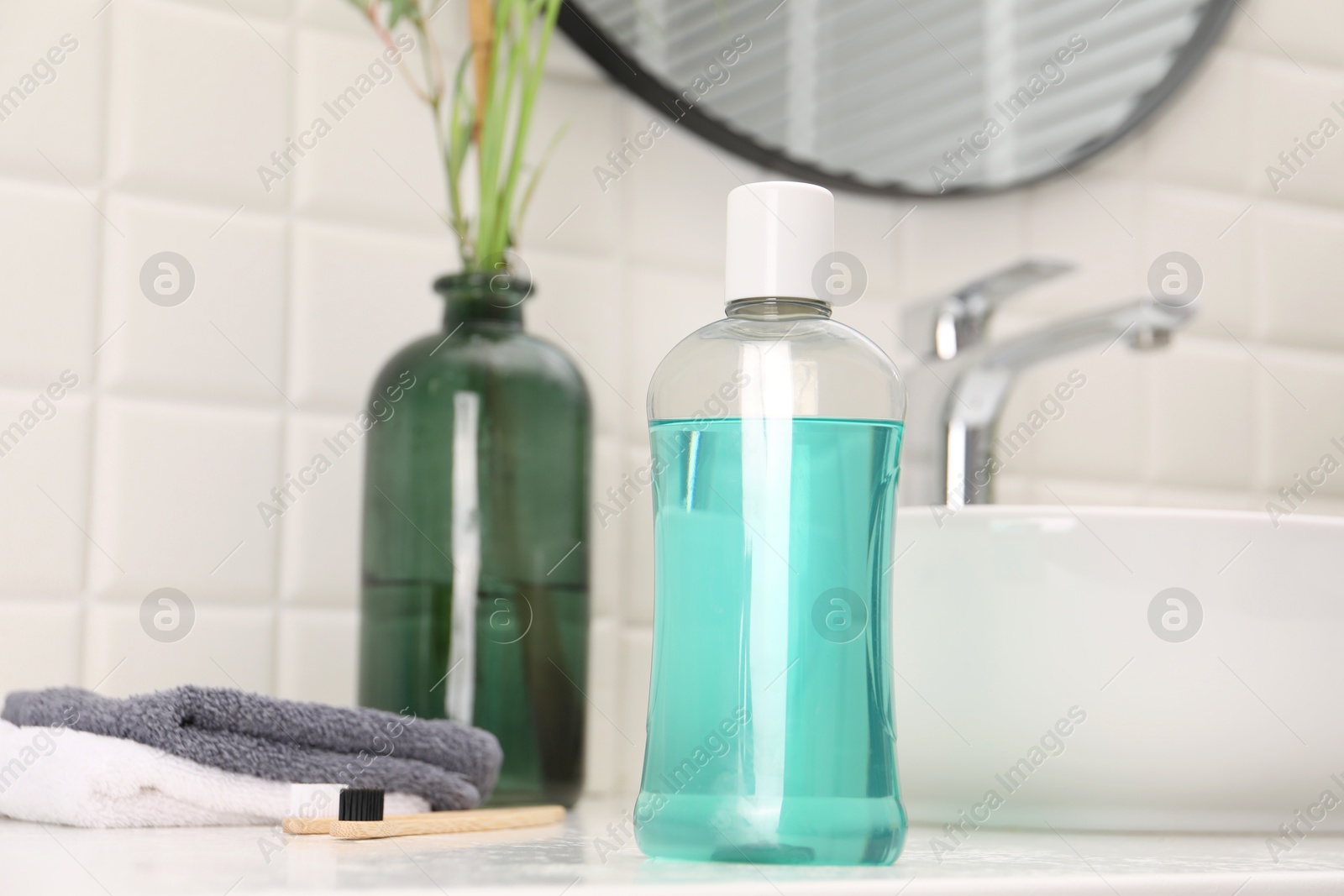 Photo of Bottle of mouthwash on white table in bathroom