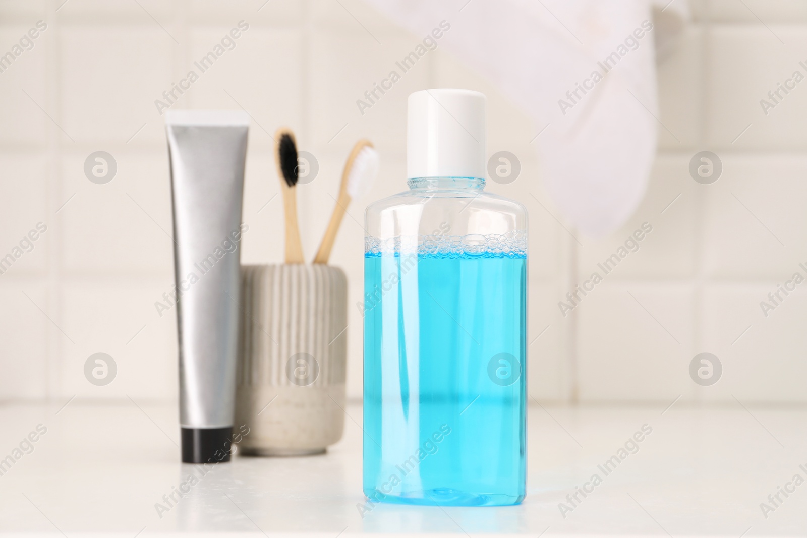 Photo of Bottle of mouthwash on white table in bathroom