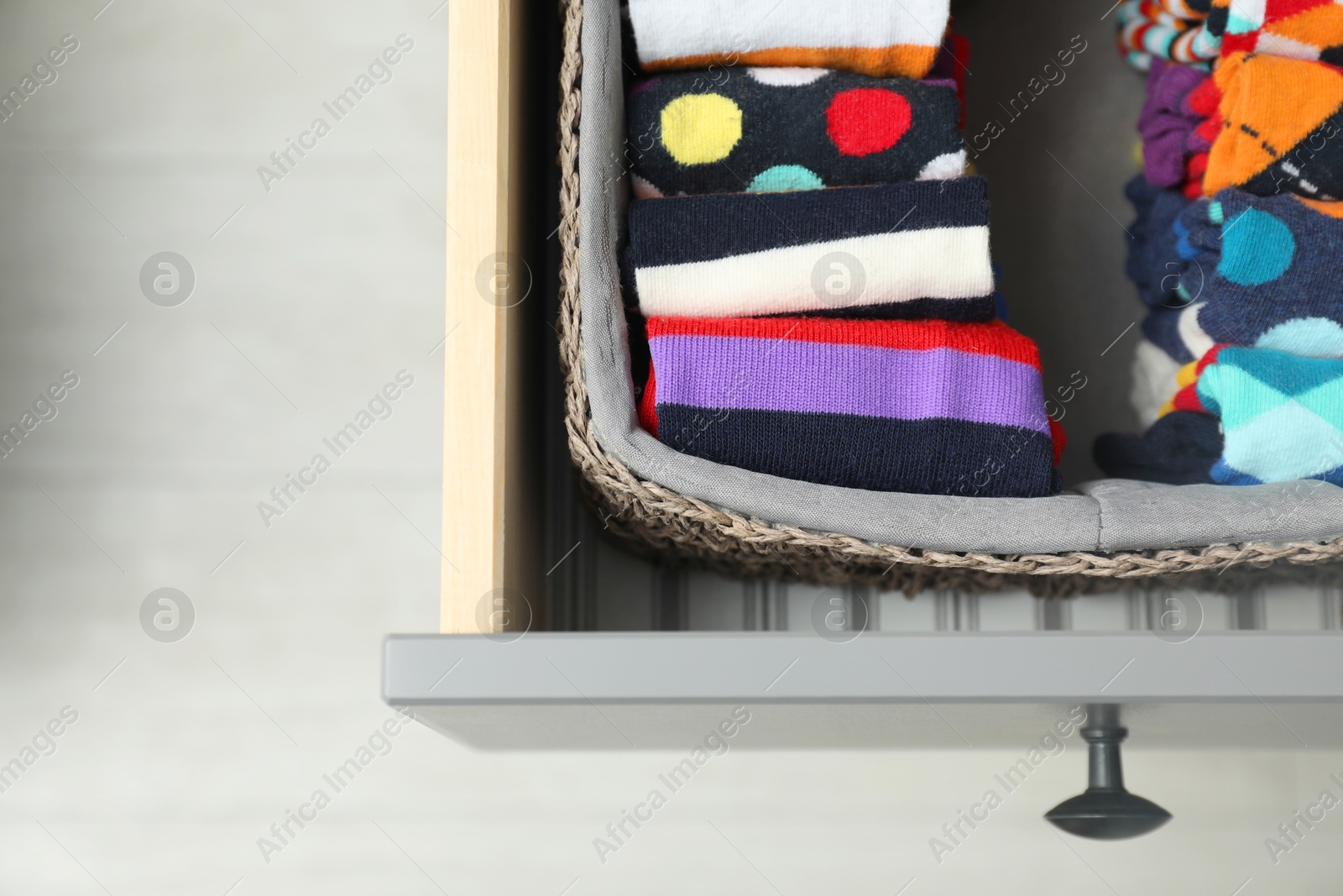 Photo of Chest of drawers with different socks indoors, top view. Space for text