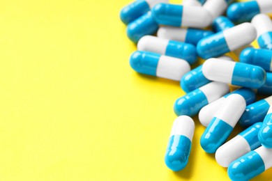 Photo of Many antibiotic pills on light blue background, closeup. Space for text